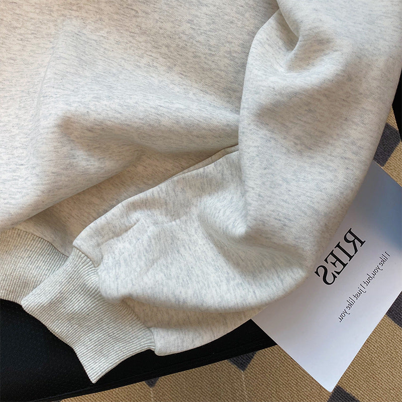 Close-up of a beige sweatshirt with a brand tag from Meleche or Meléche (short as (Mé))