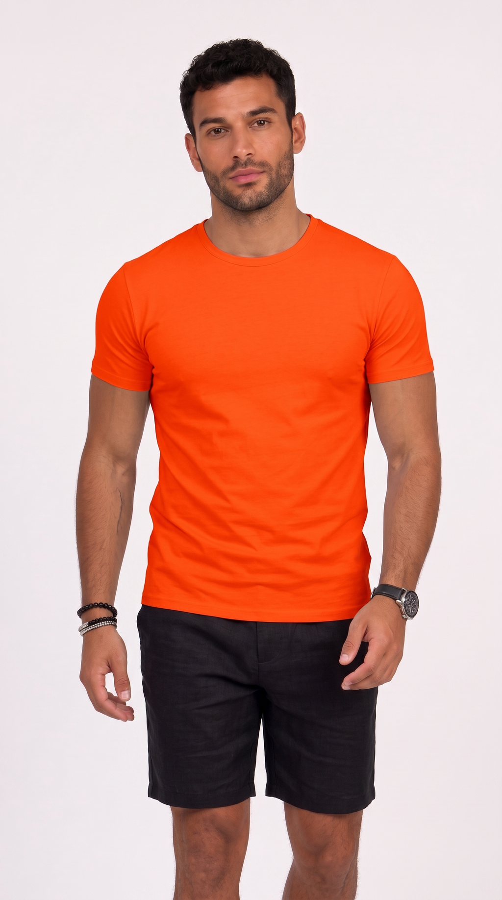 A man wearing a bright orange crew-neck t-shirt and black shorts, standing against a plain white studio background, from Meleche Fashion USA or Meléche (short as (Mé))