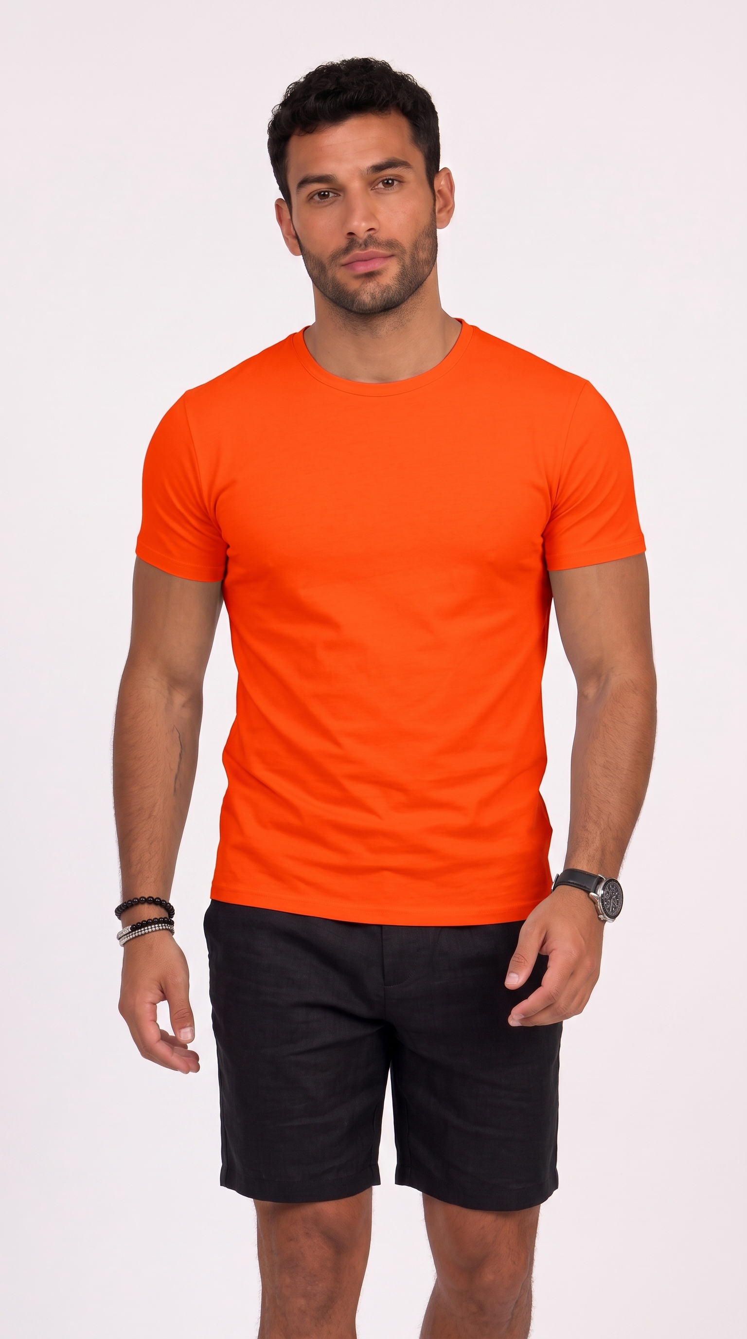 A man wearing a bright orange crew-neck t-shirt and black shorts, standing against a plain white studio background, from Meleche Fashion USA or Meléche (short as (Mé))