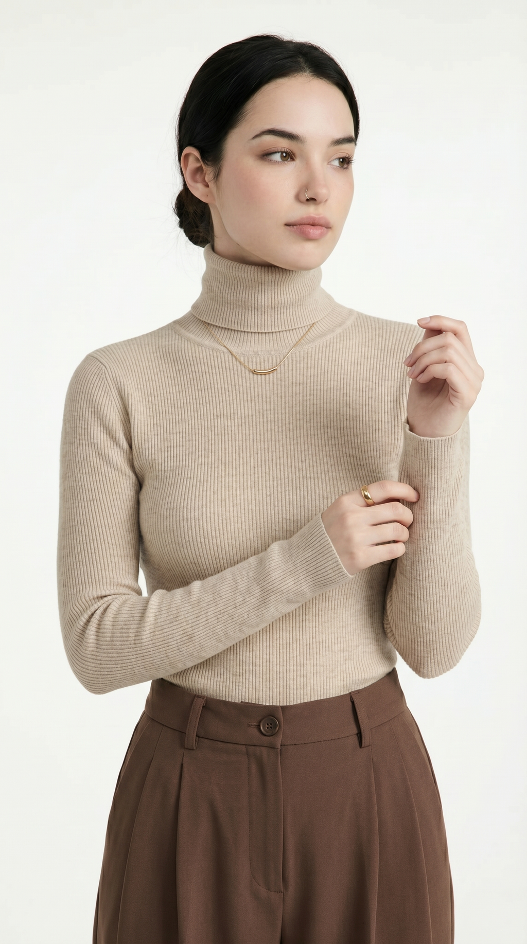 Woman wearing a beige turtleneck sweater and brown pants on a white background from Meleche USA or Meléche (short as (Mé))