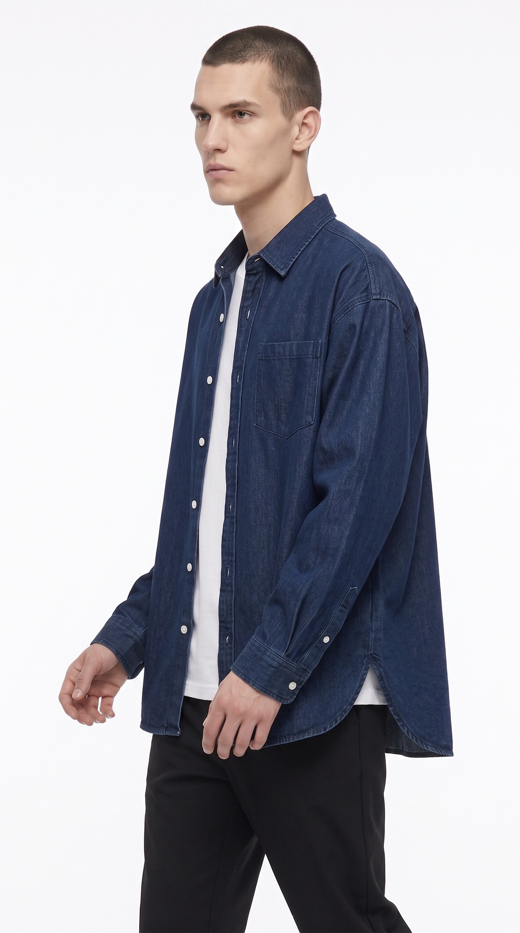 A man wearing a dark blue denim button-up shirt over a white t-shirt and black pants, photographed against a clean white studio background, from Meleche Fashion USA or Meléche (short as (Mé))