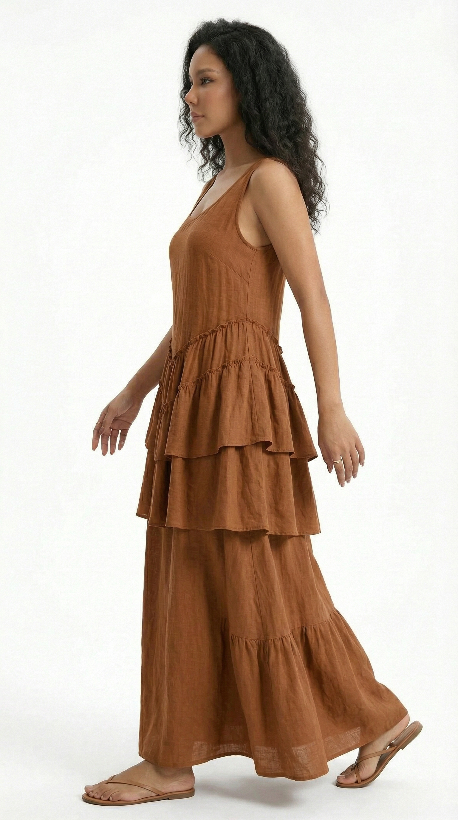 Woman wearing a beige dress with ruffled sleeves on a white background