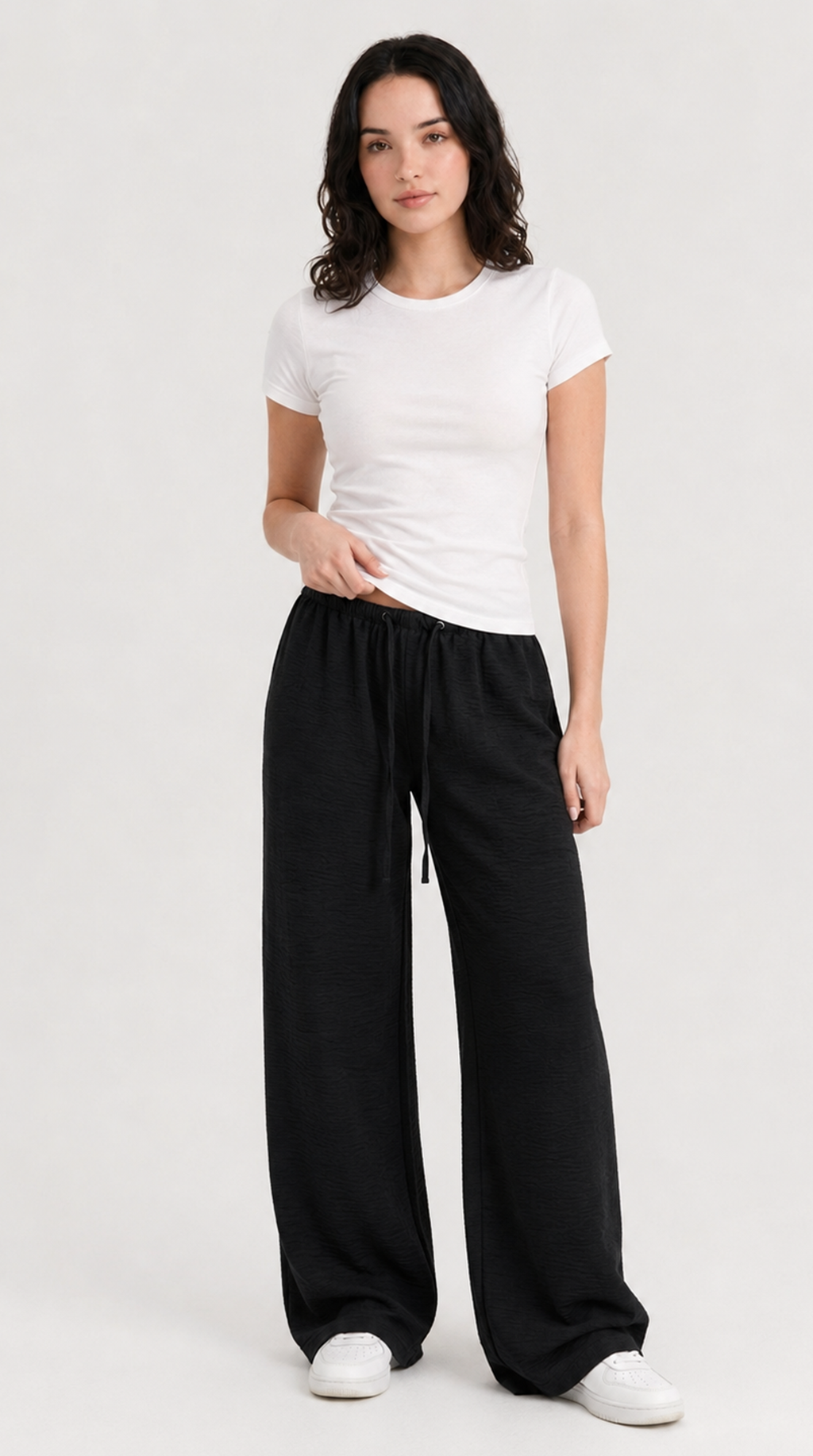 Woman wearing a white t-shirt and black wide-leg pants on a white background, from Meleche Fashion USA or Meléche (short as (Mé))