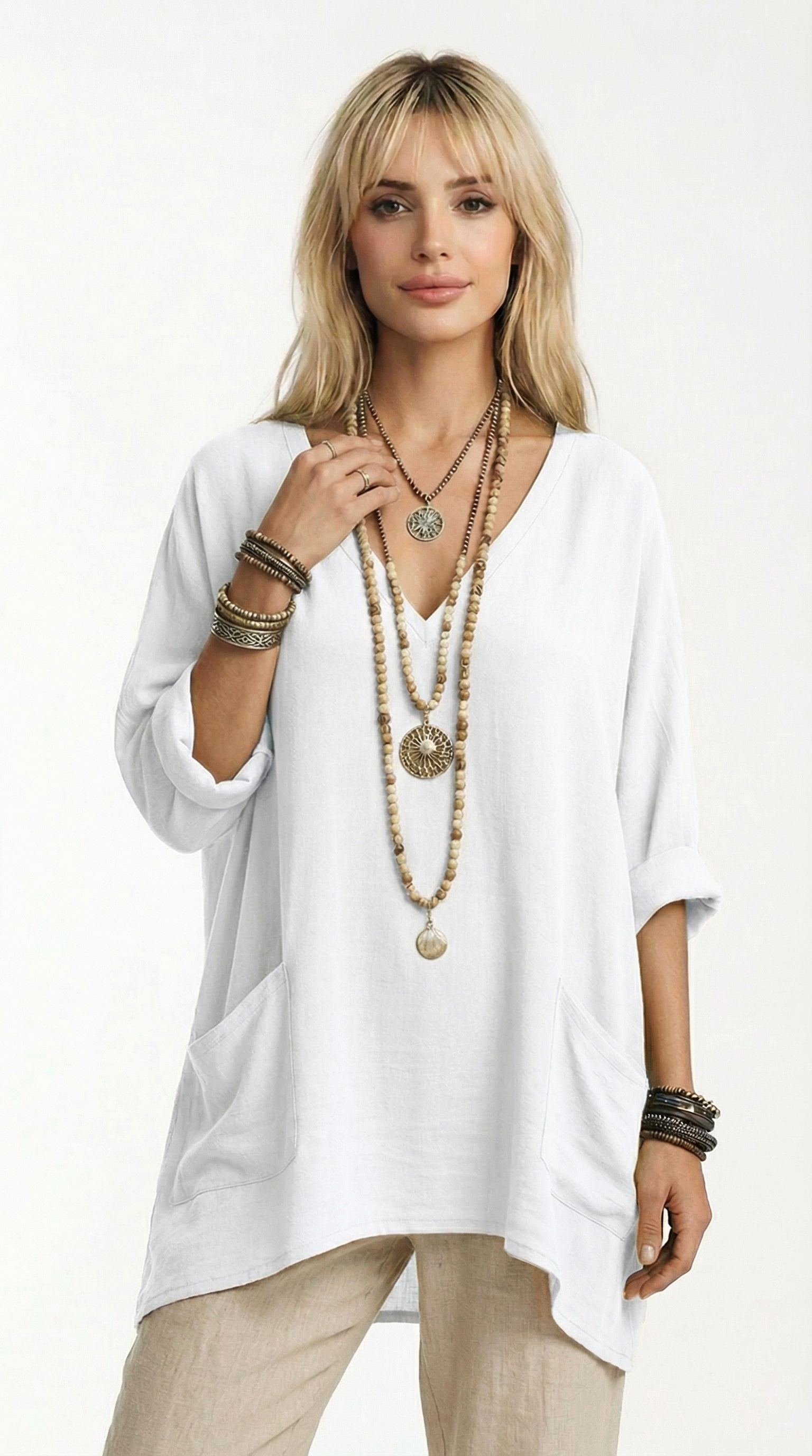 Woman wearing a white tunic with layered necklaces and bracelets on a white background from Meleche or Meléche (short as (Mé))