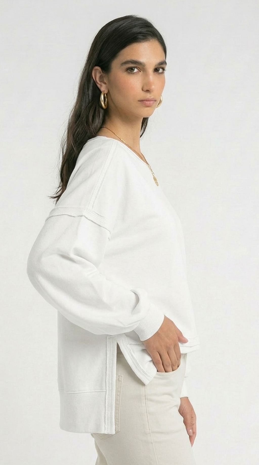 Woman wearing a white blouse and pants on a plain background