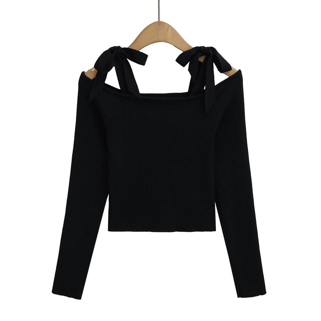 Black long-sleeve top with bow details on a hanger from Meleche or Meléche (short as (Mé))