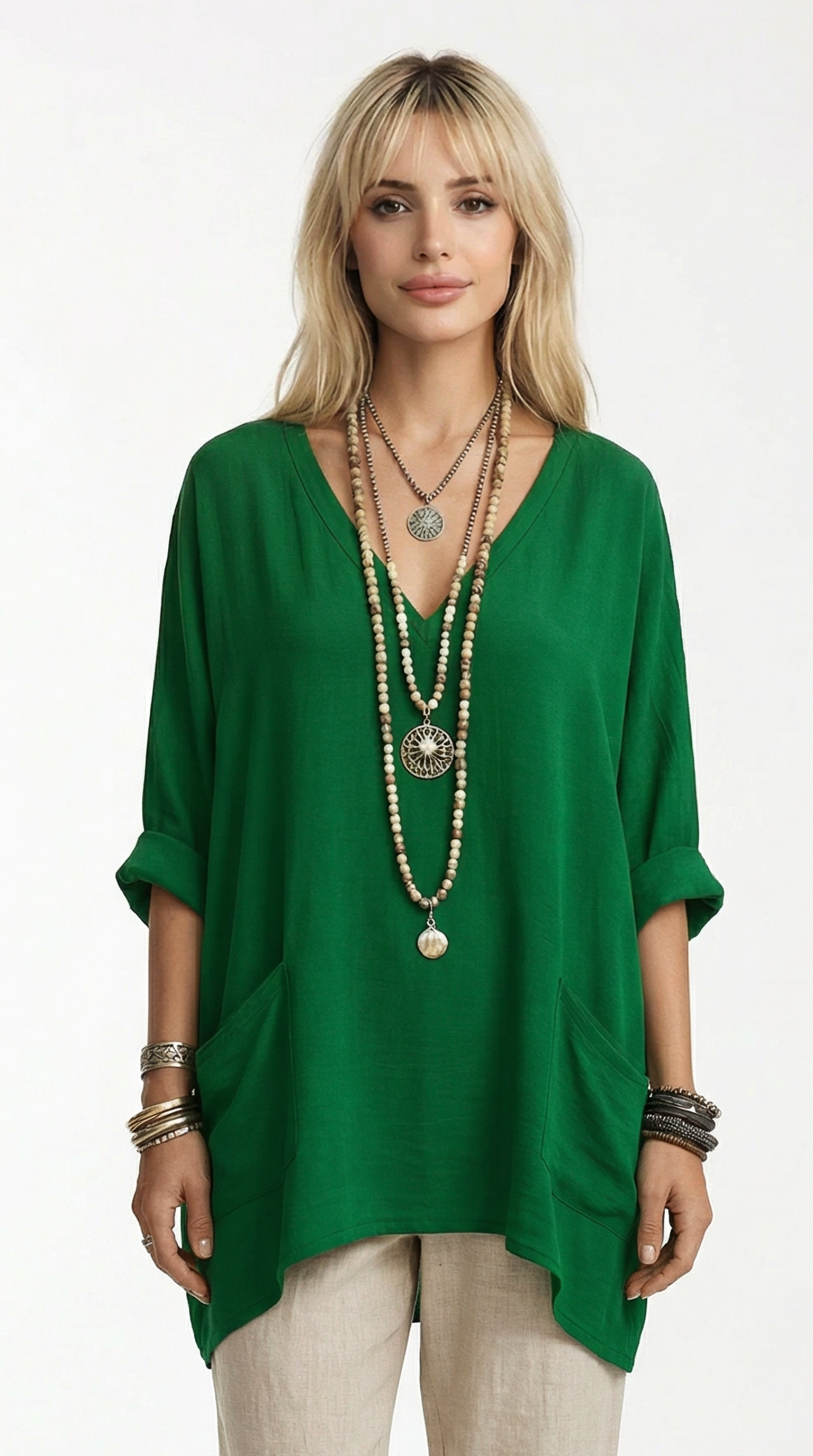 Woman wearing a green top and beige pants with multiple necklaces on a white background from Meleche or Meléche (short as (Mé))