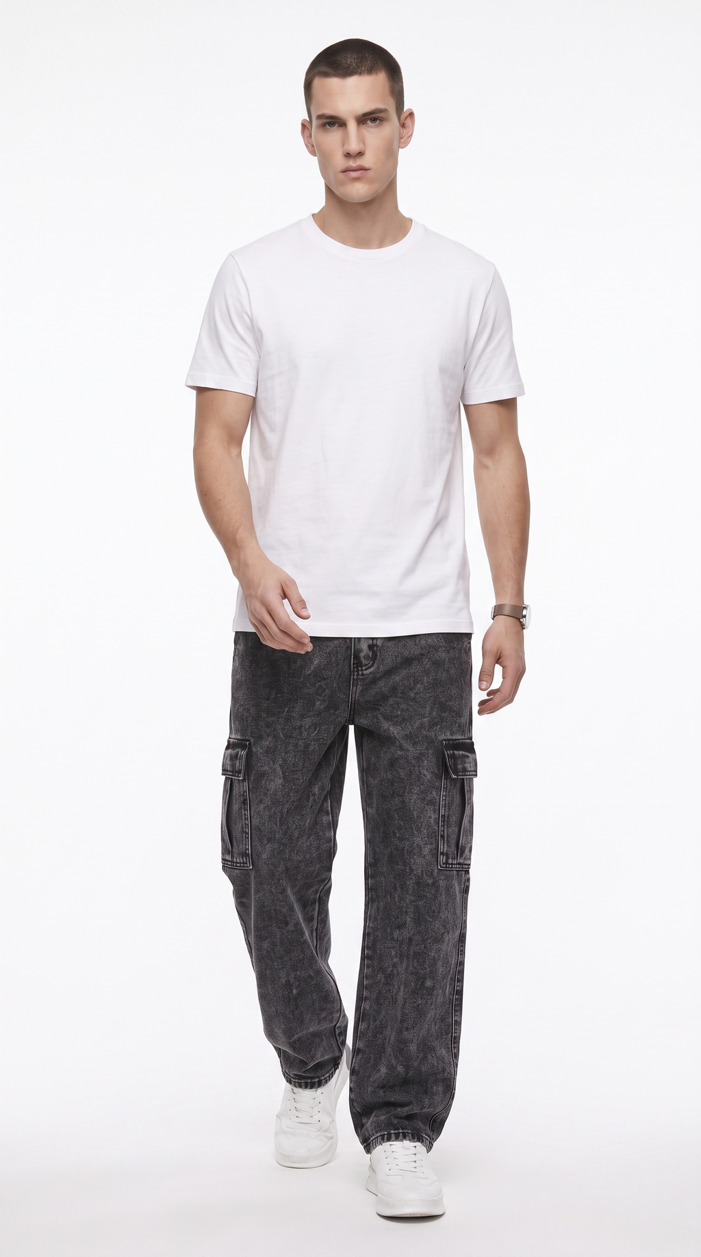 A man modeling a plain white short-sleeve crewneck t-shirt, paired with dark gray washed cargo pants and white sneakers, against a solid white studio background, from Meleche Fashion USA or Meléche (short as (Mé))