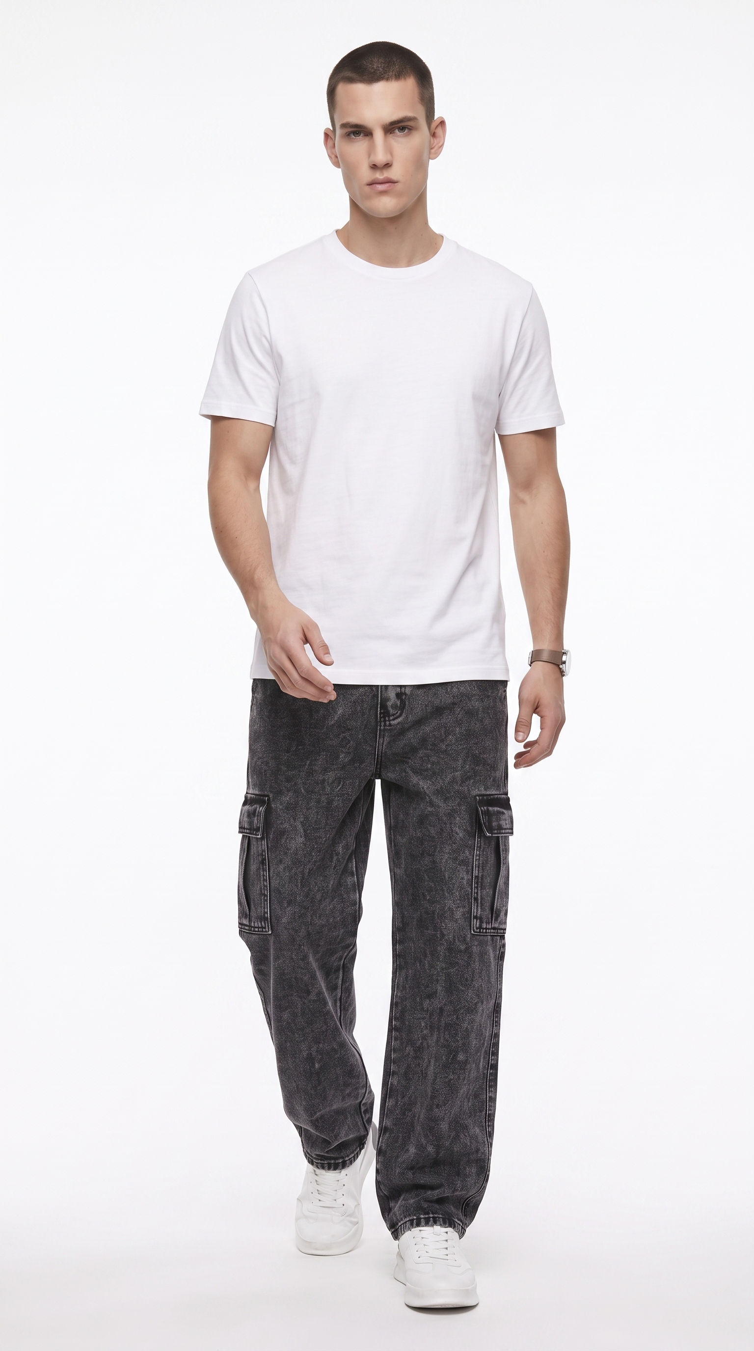 A man modeling a plain white short-sleeve crewneck t-shirt, paired with dark gray washed cargo pants and white sneakers, against a solid white studio background, from Meleche Fashion USA or Meléche (short as (Mé))