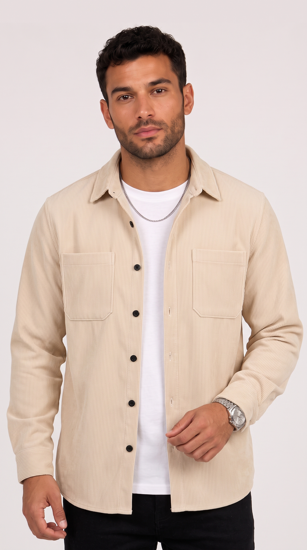 A man wearing a light beige long-sleeve button-up shirt over a white t-shirt and black pants, photographed against a plain light background, from Meleche Fashion USA or Meléche (short as (Mé))
