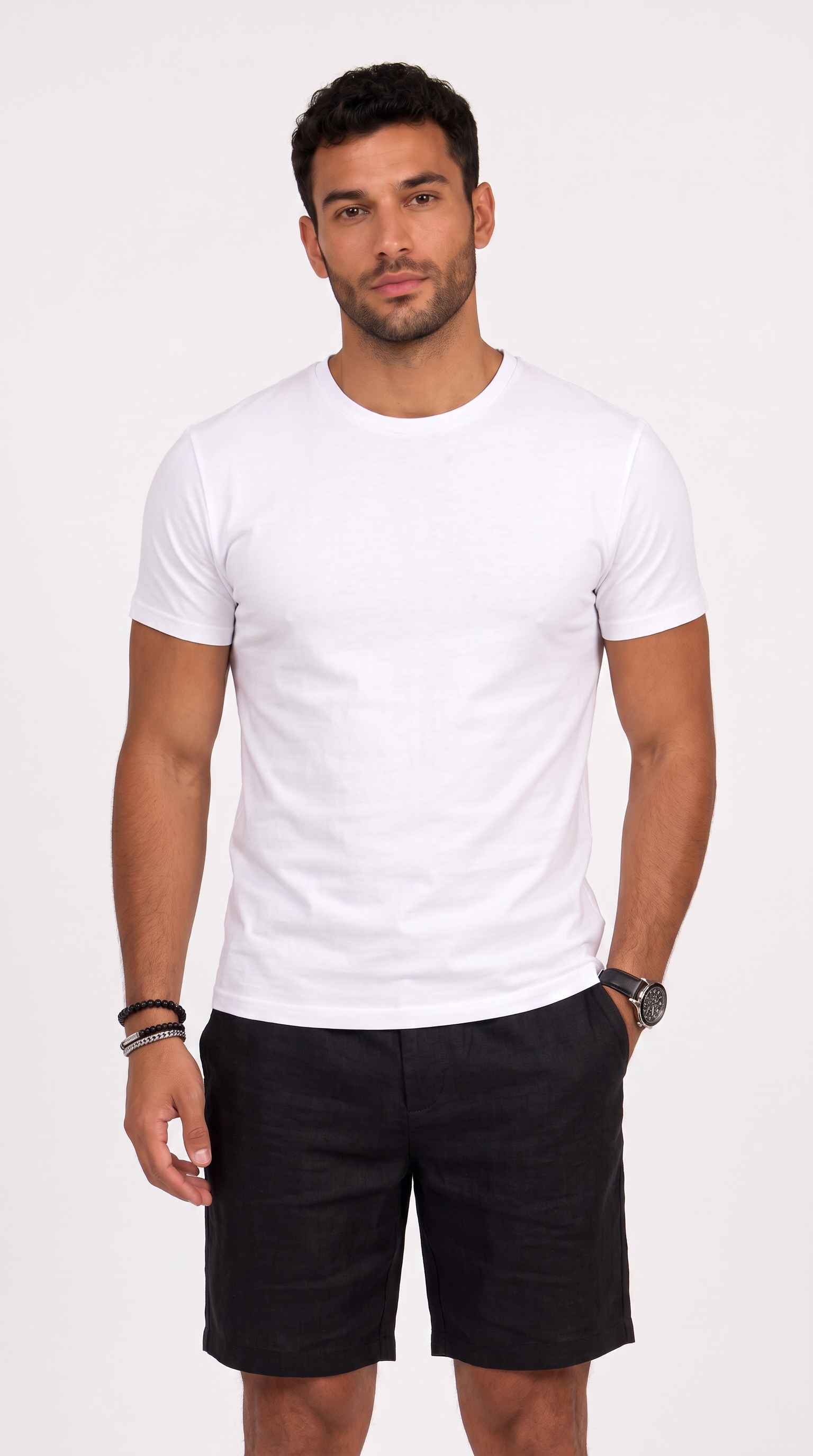 A man wearing a plain white short-sleeve crewneck t-shirt and black shorts, standing against a light gray studio background, from Meleche Fashion USA or Meléche (short as (Mé))