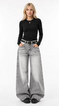 Woman wearing a black long-sleeve top and gray wide-leg jeans on a white background jeans from Meleche Fashion USA or Meléche (short as (Mé))