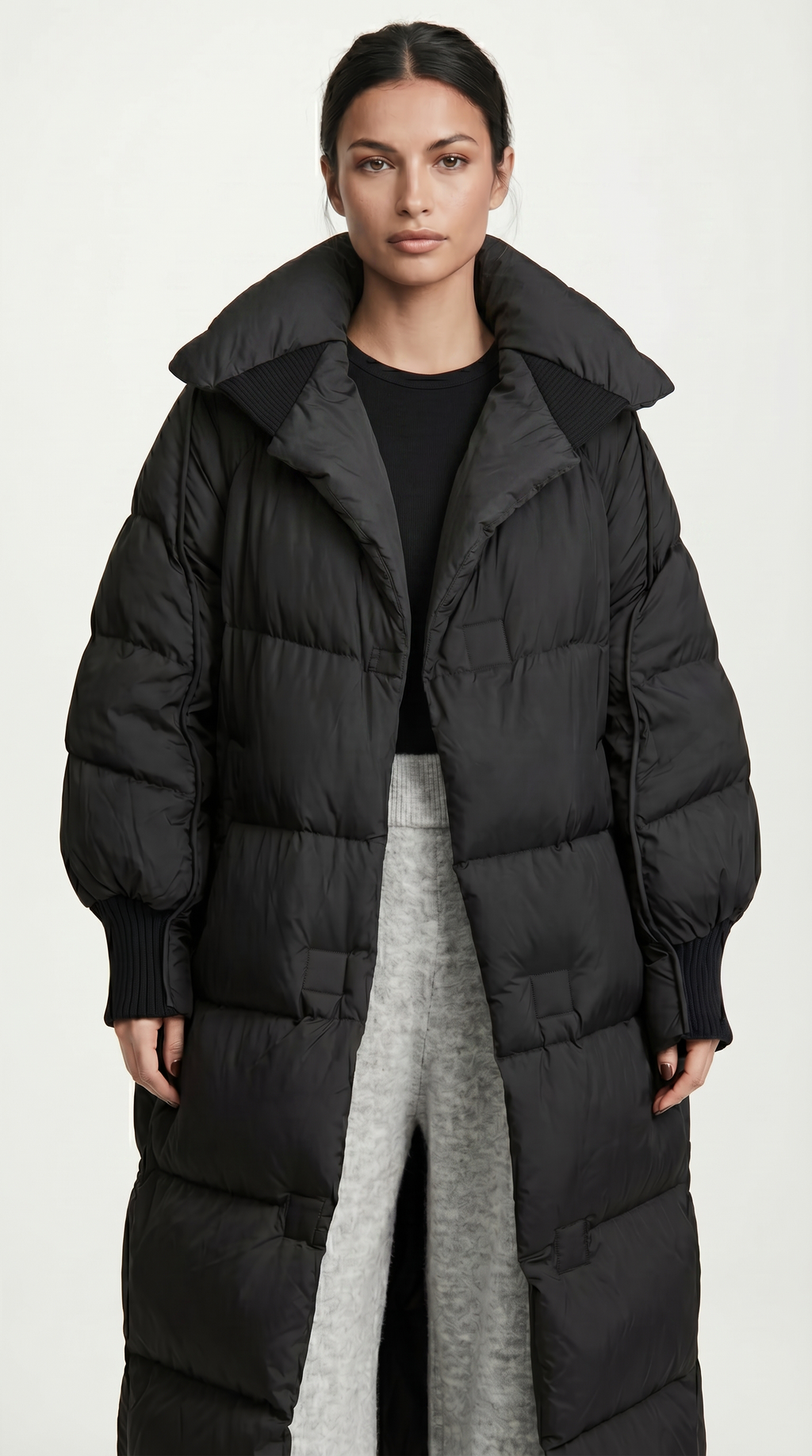 Woman wearing a long black puffer coat on a white background from Meleche or Meléche USA (short as (Mé))