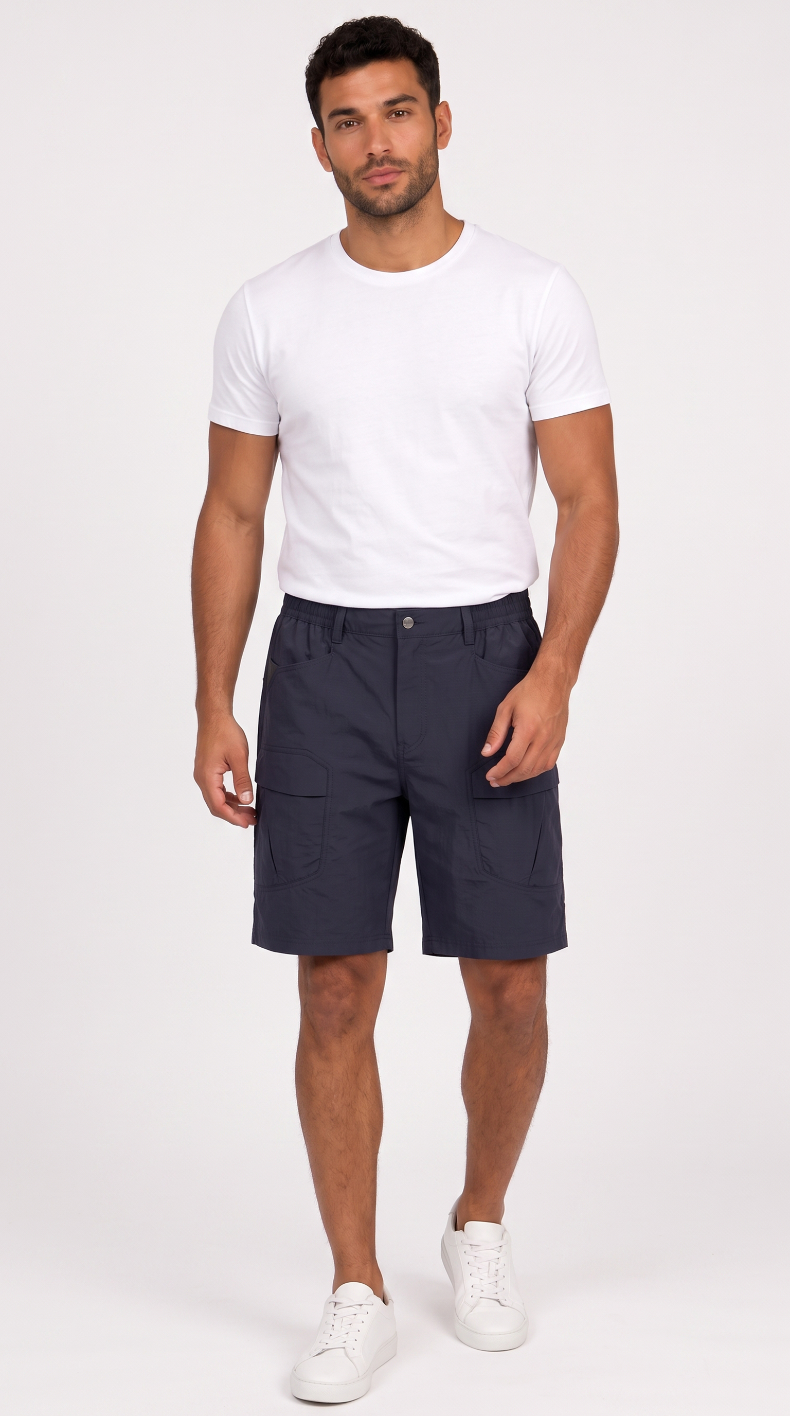 A man modeling a pair of dark navy blue shorts, paired with a white t-shirt and white sneakers, standing against a plain white studio background, from Meleche Fashion USA or Meléche (short as (Mé))