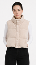 Woman wearing a beige corduroy vest over a white shirt on a white background from Meleche Fashion USA or Meléche (short as (Mé))