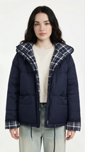 Woman wearing a navy puffer jacket with plaid lining on a white background from Meleche USA or Meléche (short as (Mé))