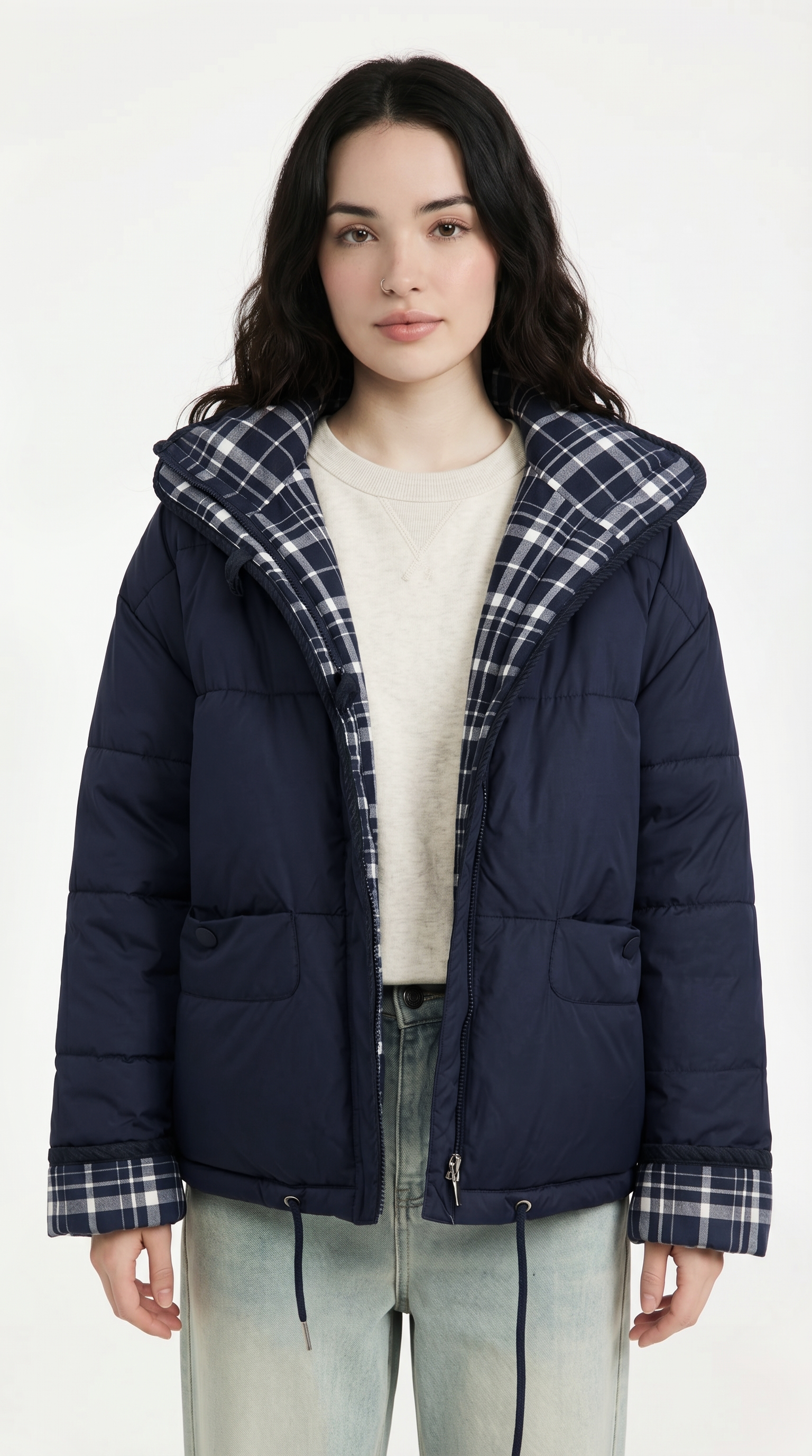Woman wearing a navy puffer jacket with plaid lining on a white background from Meleche USA or Meléche (short as (Mé))