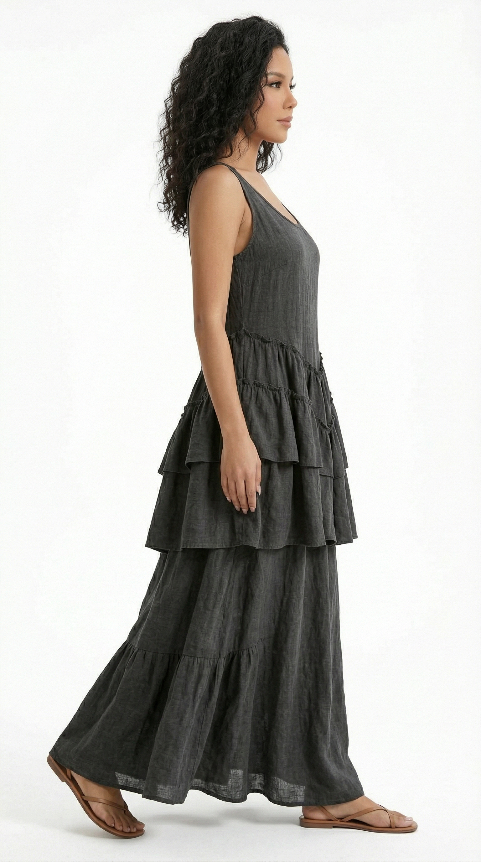 Woman wearing a dark gray tiered dress on a white background