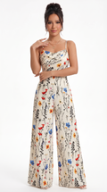 Woman wearing a floral jumpsuit on a white background, from Meleche Fashion USA or Meléche (short as (Mé))