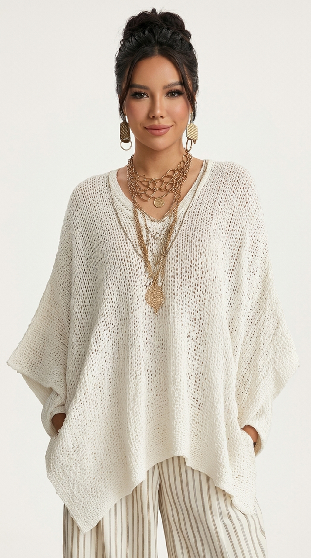 Woman wearing a white knit poncho with layered necklaces on a white background from Meleche or Meléche (short as (Mé))
