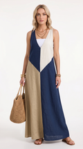 Woman wearing a long, color-blocked dress with a white, blue, and beige pattern, holding a woven bag, from Meleche Fashion USA or Meléche (short as (Mé))
