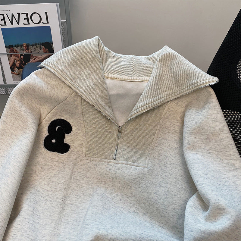 Light gray hoodie with a black logo on the chest pocket from Meleche or Meléche (short as (Mé))