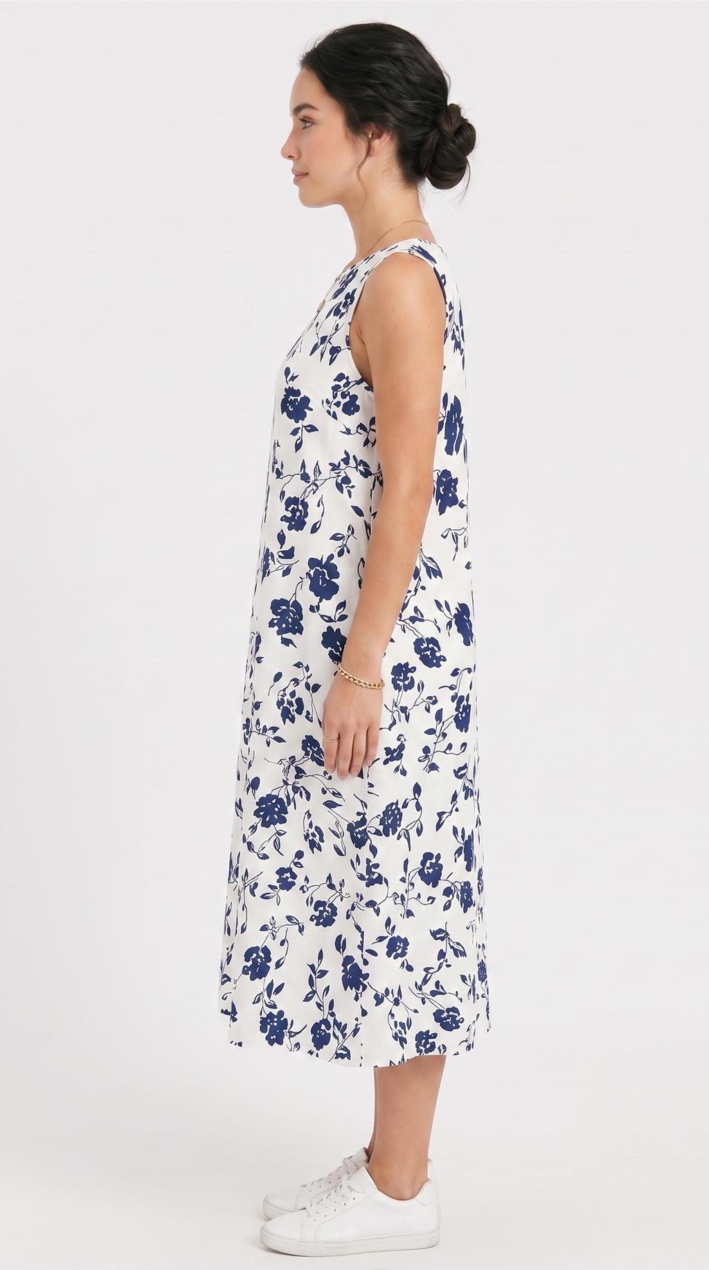 Woman wearing a white dress with blue floral pattern on a white background
