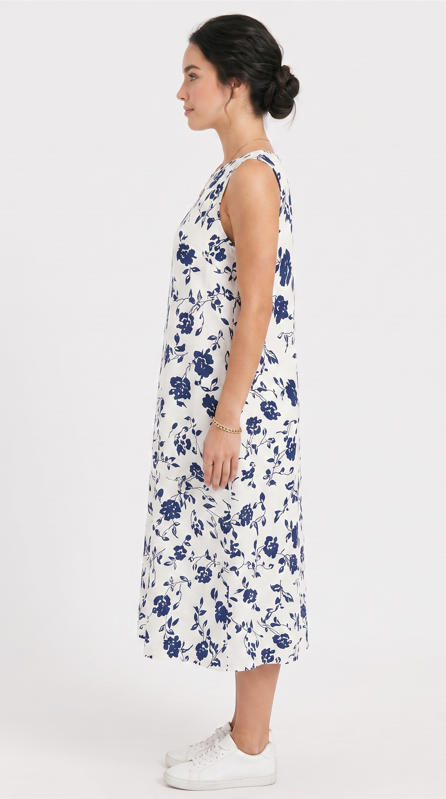 Woman wearing a white dress with blue floral pattern on a white background