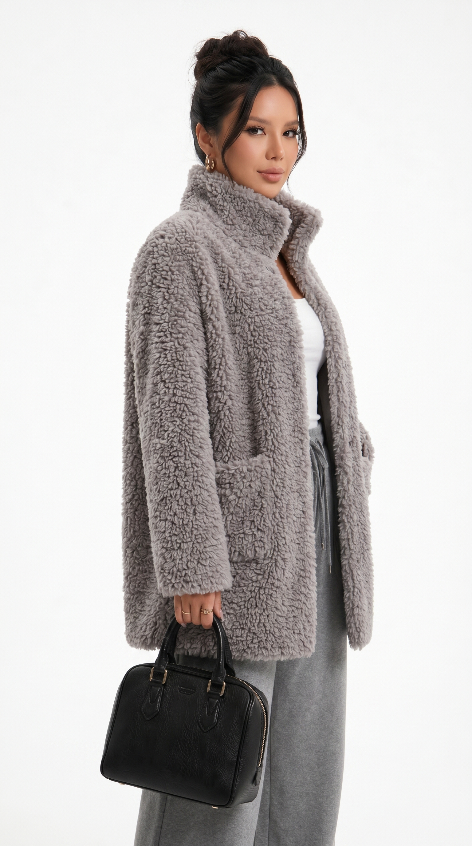 Woman wearing a gray teddy coat holding a black handbag on a white background from Meleche Fashion USA or Meléche (short as (Mé))