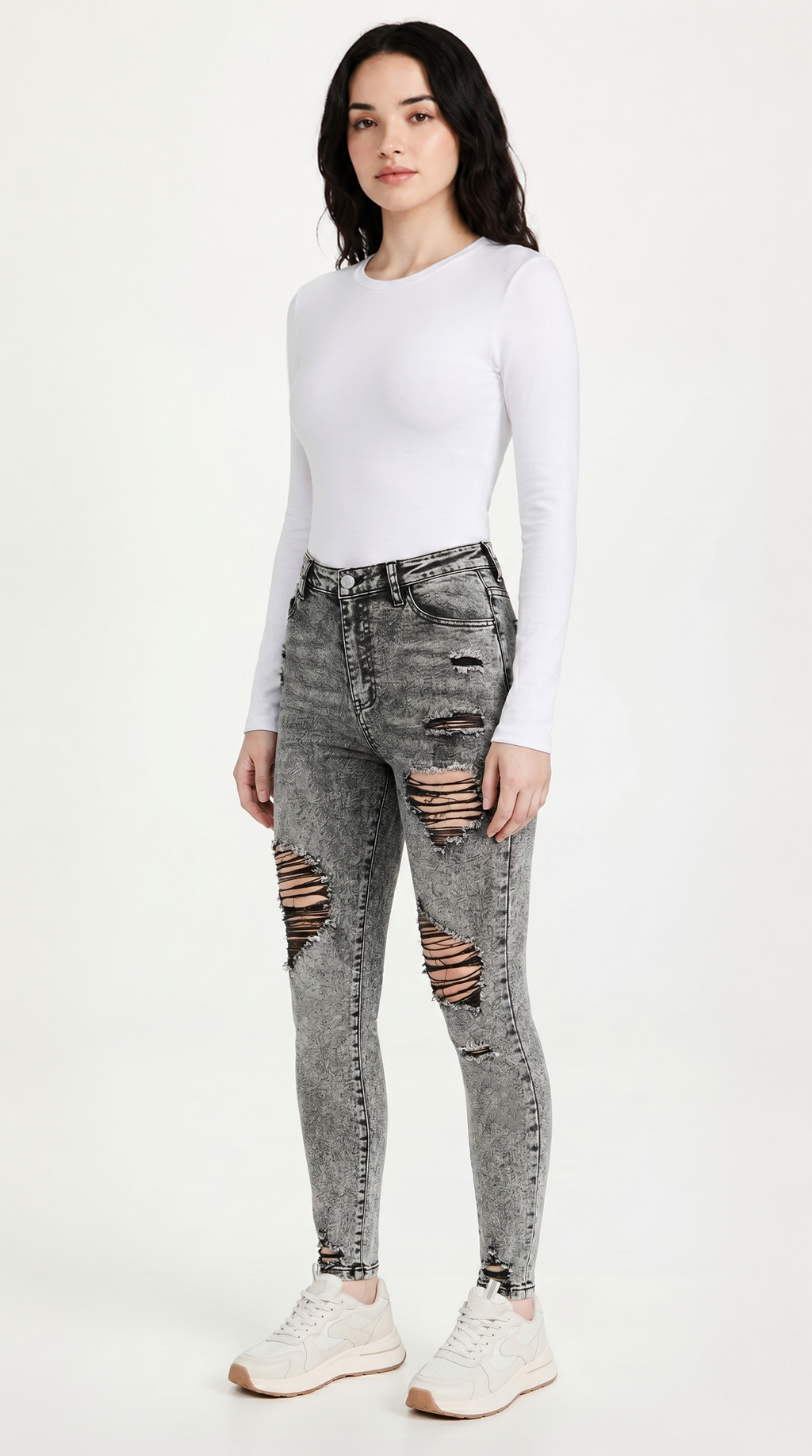 Woman wearing ripped gray jeans and a white long-sleeve top on a white background, slim fit Skinny jeans from Meleche Fashion USA or Meléche (short as (Mé))
