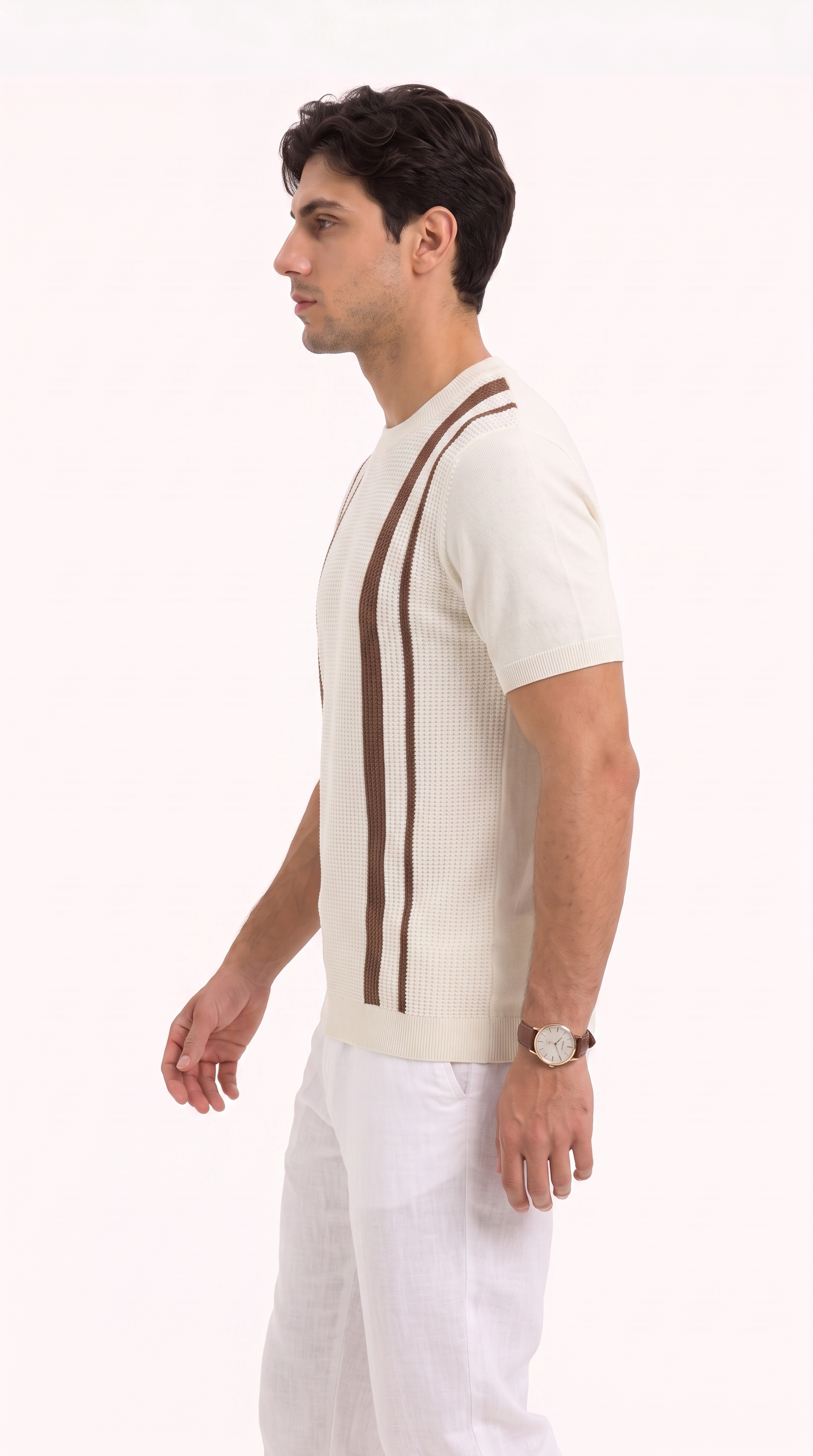 A man in profile wearing a cream ribbed short-sleeve knit sweater with two vertical brown stripes on the chest, paired with white trousers, against a plain white studio background, from Meleche Fashion USA or Meléche (short as (Mé))