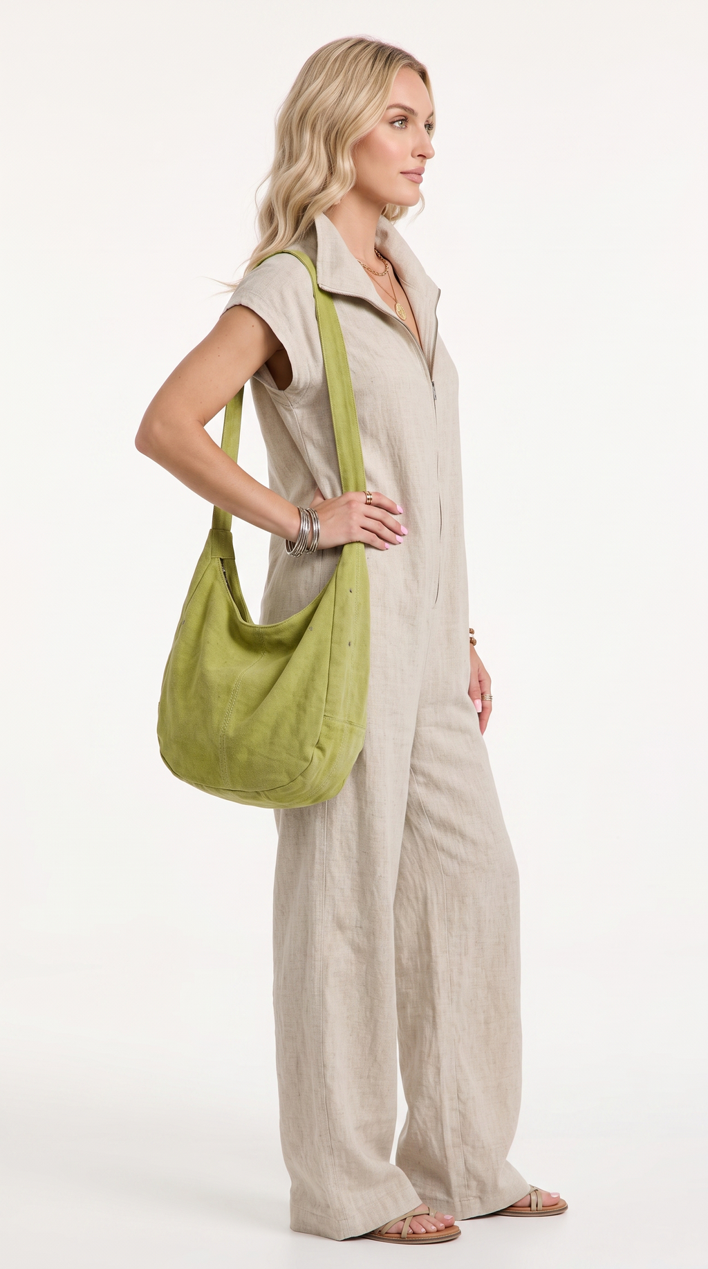 A woman modeling a light beige linen jumpsuit and carrying a sage green linen shoulder bag against a plain white studio background, from Meleche Fashion USA or Meléche (short as (Mé))