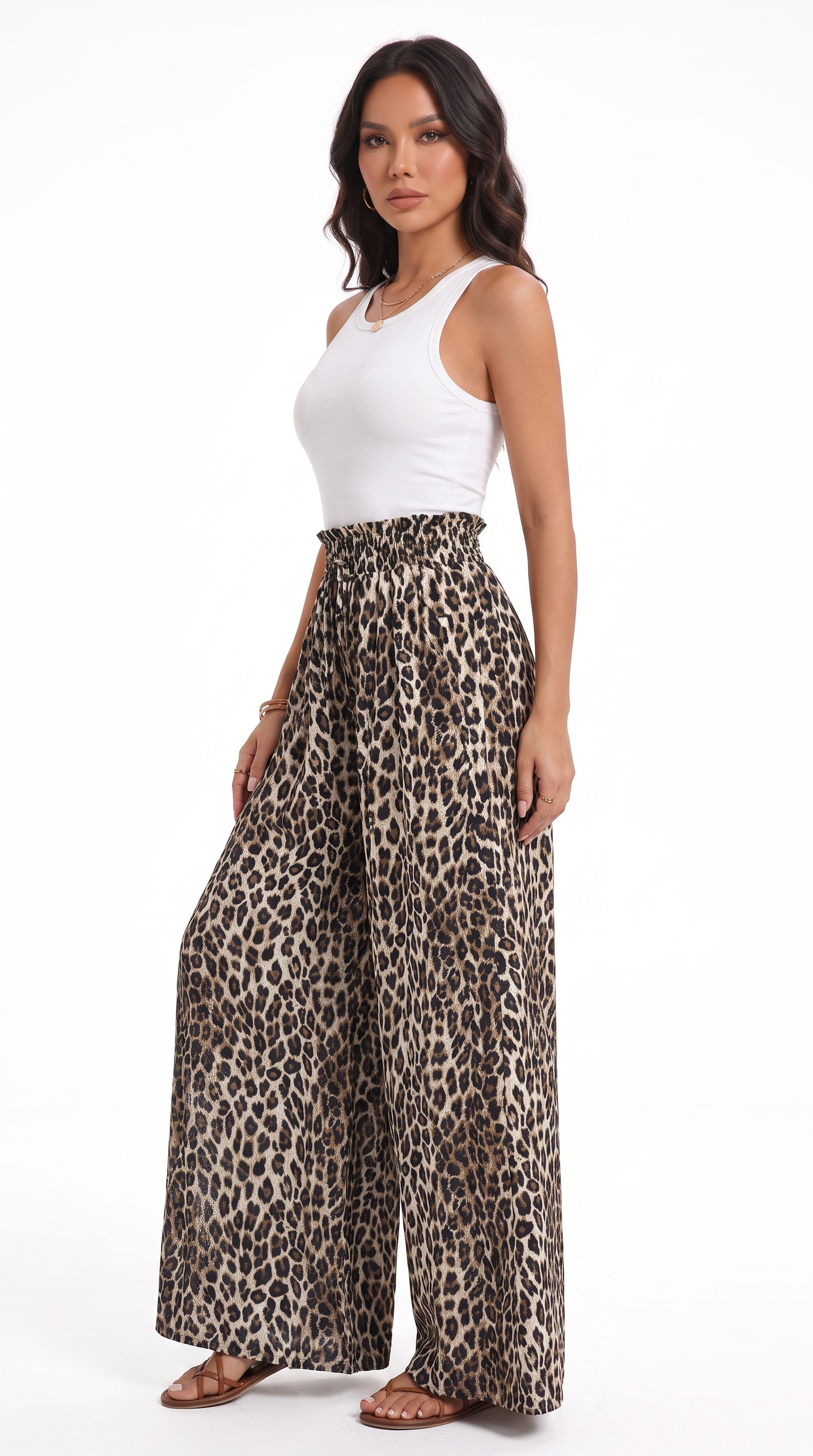 A woman modeling high-waisted, wide-leg leopard print pants with a white ribbed tank top, standing against a plain white studio background, from Meleche Fashion USA or Meléche (short as (Mé))