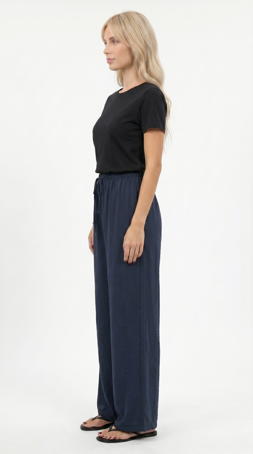 Woman wearing a black top and navy wide-leg pants on a white background, sexy loss pants from Meleche Fashion USA or Meléche (short as (Mé))