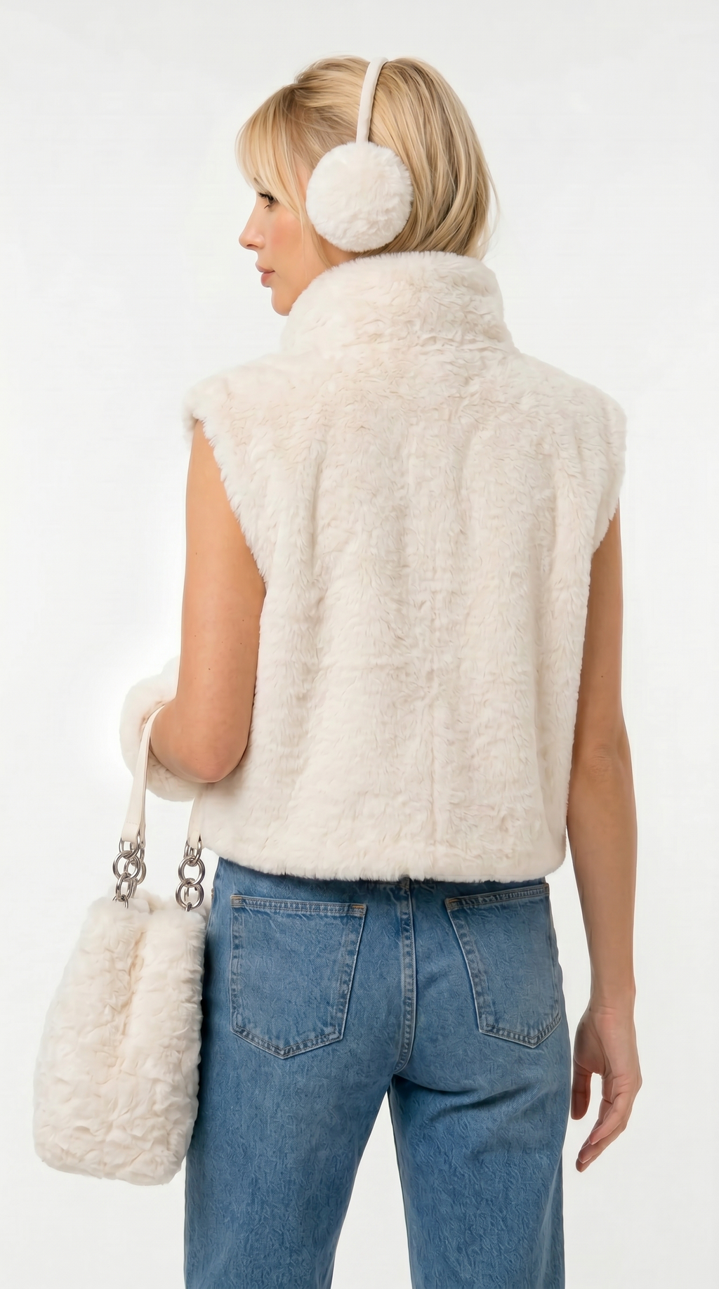 Woman wearing a cream fur vest, blue jeans, and white ear muffs on a white background from Meleche Fashion USA or Meléche (short as (Mé))
