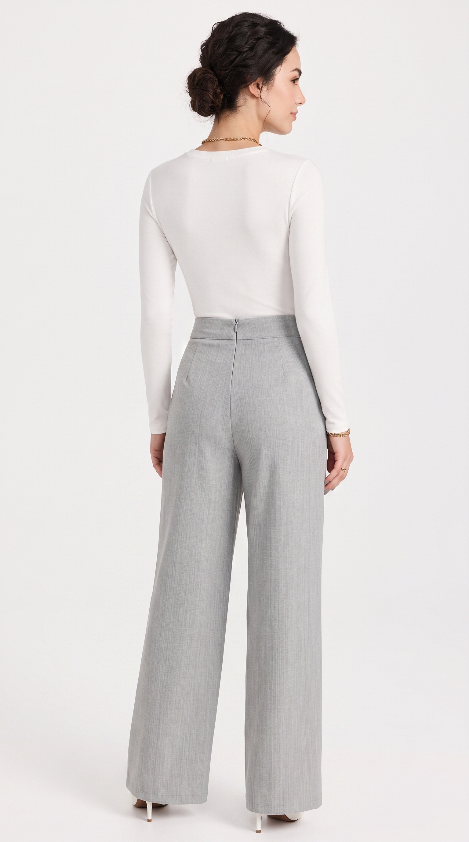 Woman wearing a white top and gray high-waisted pants on a white background