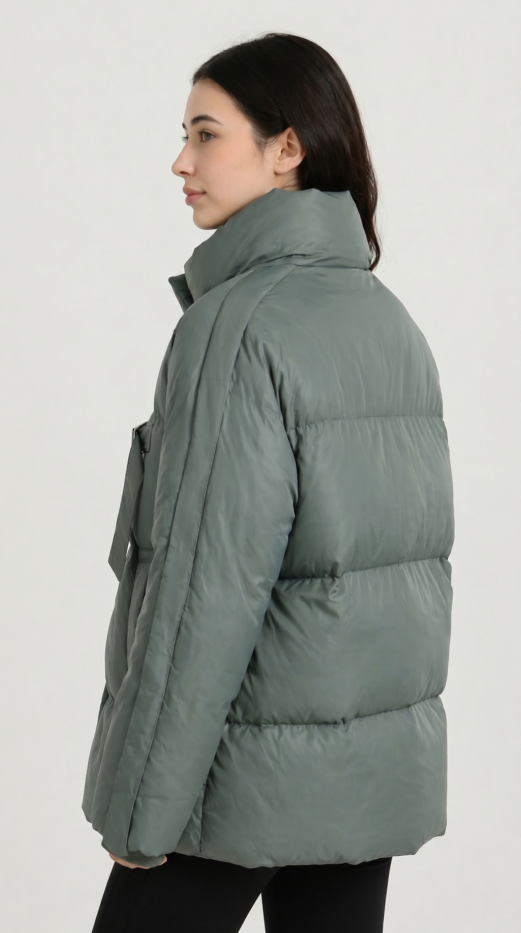 Woman wearing a green puffer jacket on a white background from Meleche USA or Meléche (short as (Mé))