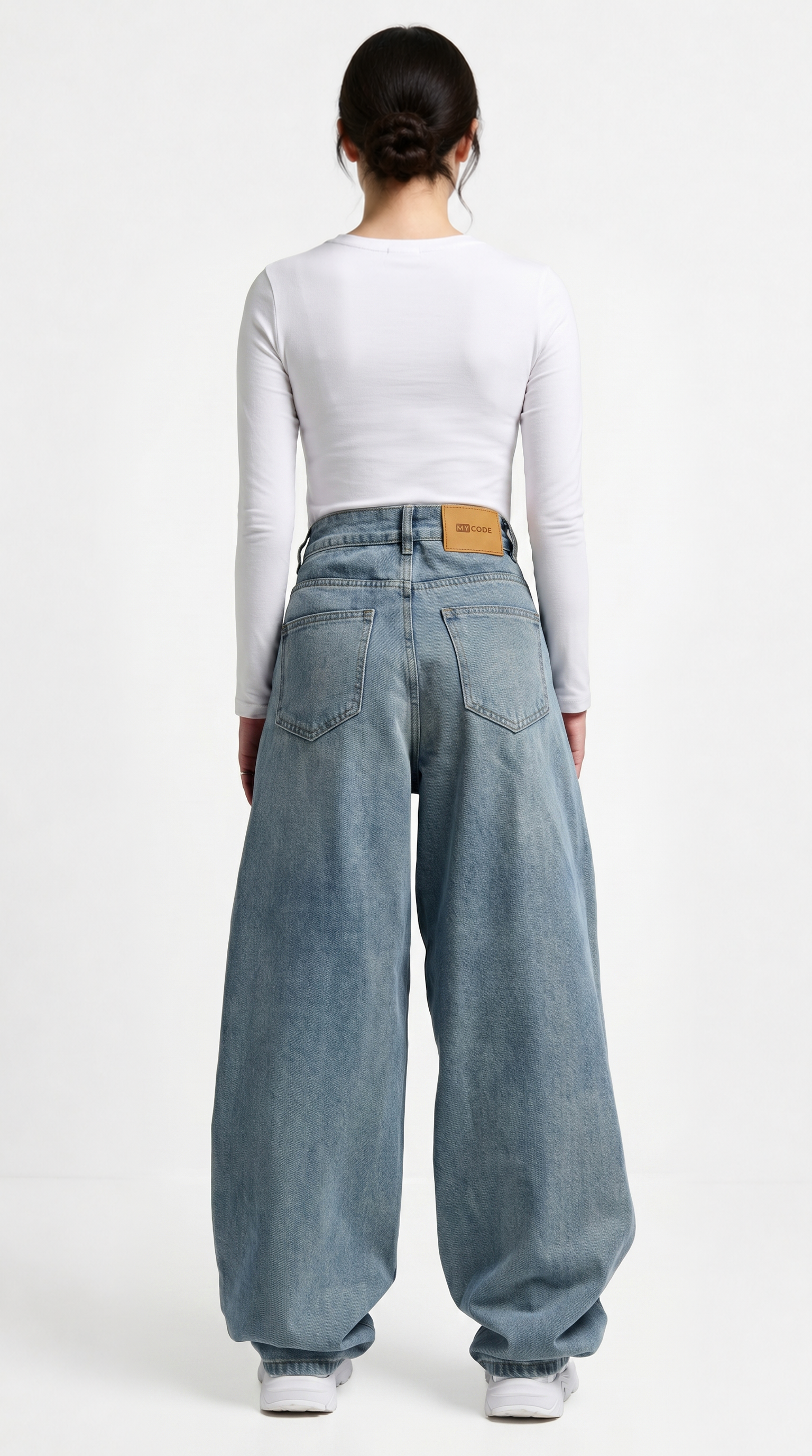 Person wearing light blue jeans and a white long-sleeve shirt on a white background, Relaxed Fit Egyptian cotton jeans from Meleche Fashion USA or Meléche (short as (Mé))