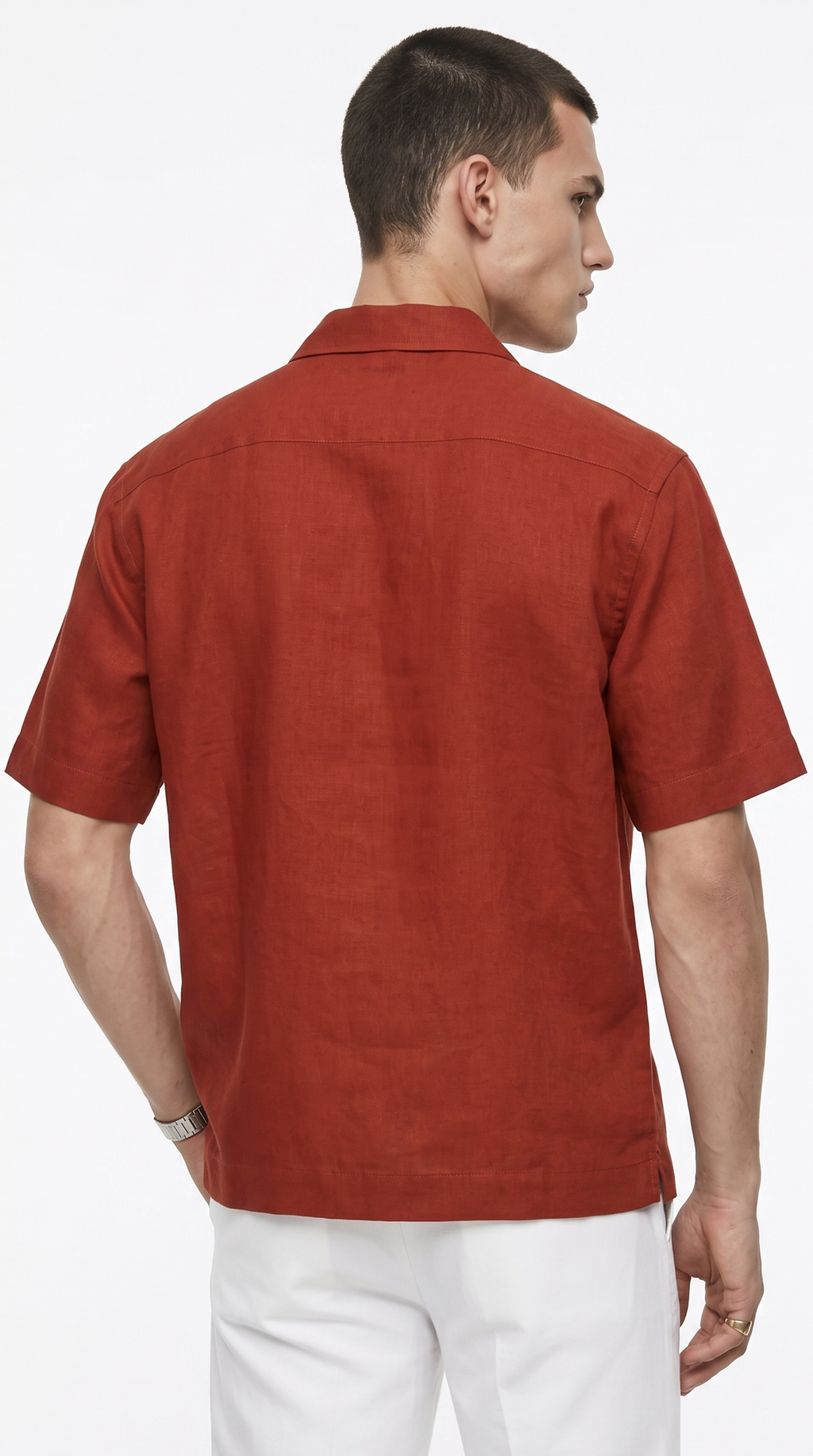 A man shown from the back wearing a rust-orange short-sleeve linen shirt and white trousers, photographed against a clean white background, from Meleche Fashion USA or Meléche (short as (Mé))