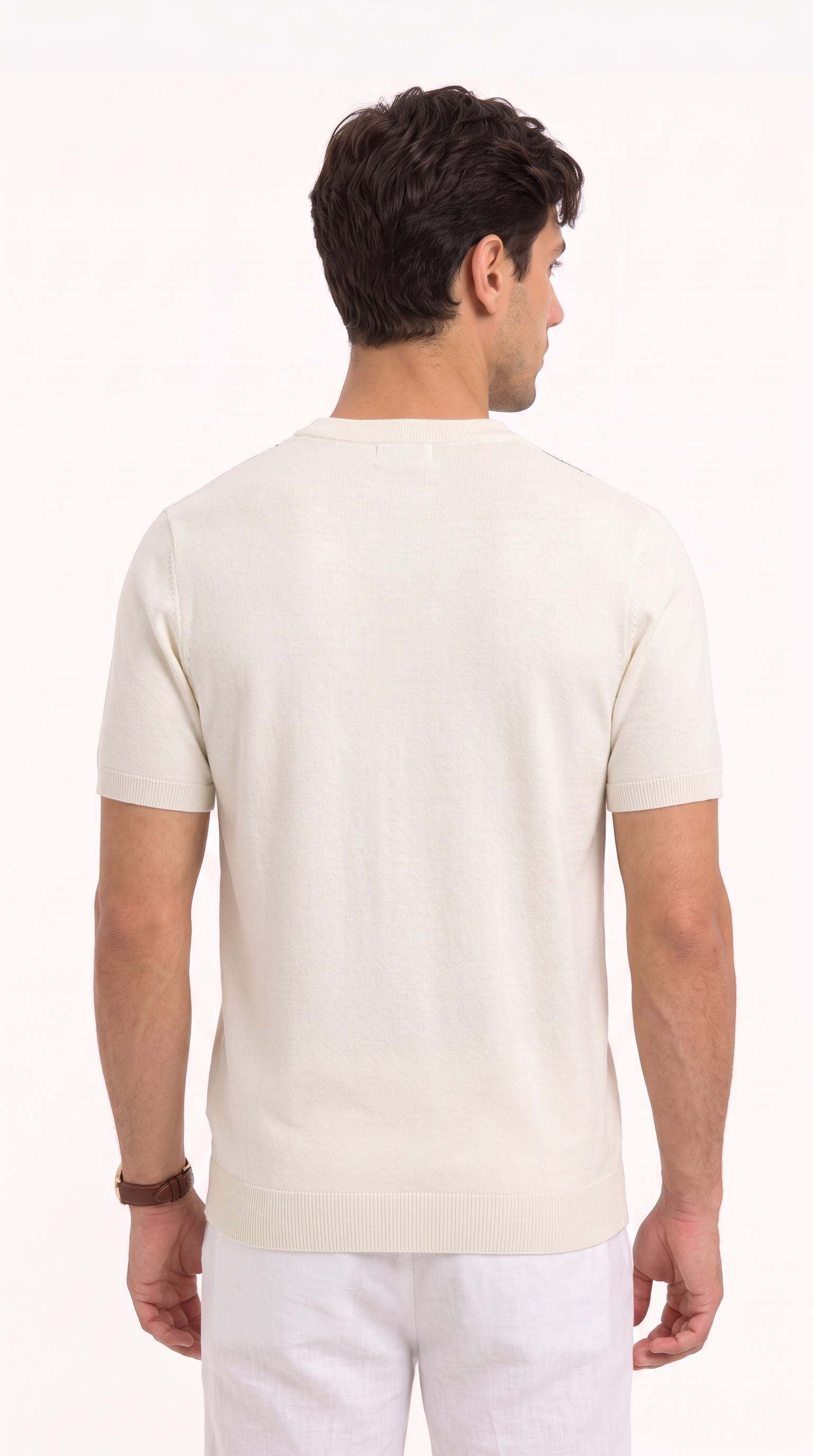 A man viewed from the back wearing a cream-colored short-sleeve knit shirt and white trousers, set against a plain white studio background, from Meleche Fashion USA or Meléche (short as (Mé))