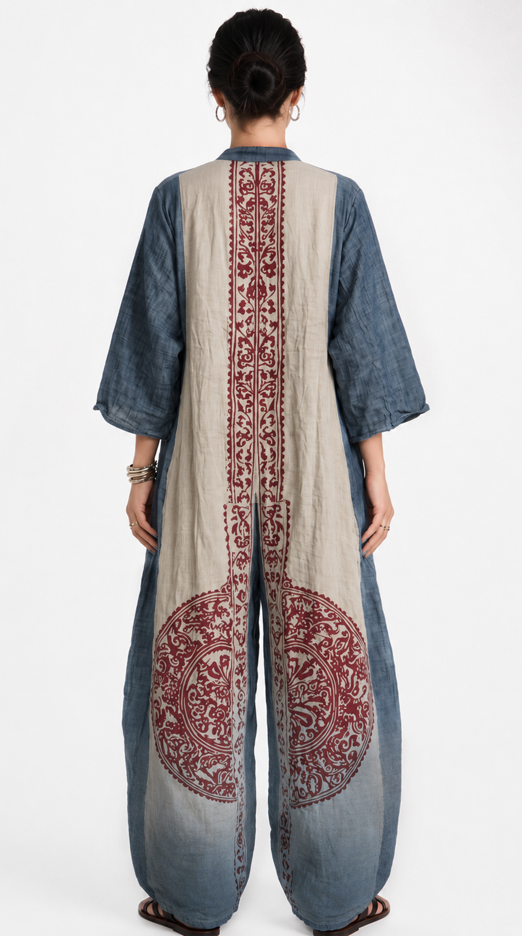 Person wearing a blue and beige outfit with intricate red patterns on a white background, from Meleche Fashion USA or Meléche (short as (Mé))