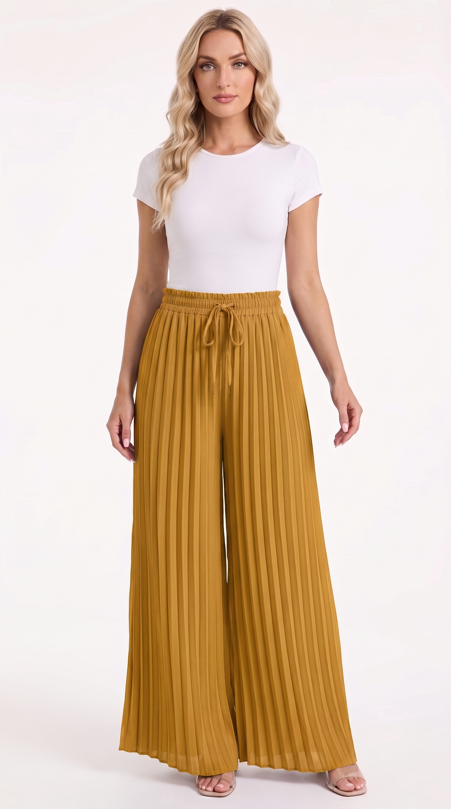 A woman modeling a white short-sleeve crewneck top and high-waisted, wide-leg pleated trousers in a rich mustard yellow color, paired with neutral sandals, against a plain white studio background, from Meleche Fashion USA or Meléche (short as (Mé))