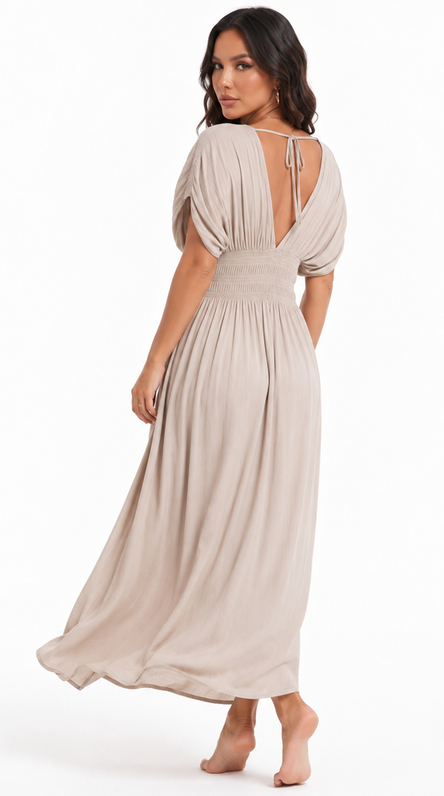 A woman modeling a light beige maxi dress with a draped open back, short puff sleeves, and a smocked waistband, shown from the back against a plain white background, from Meleche Fashion USA or Meléche (short as (Mé))