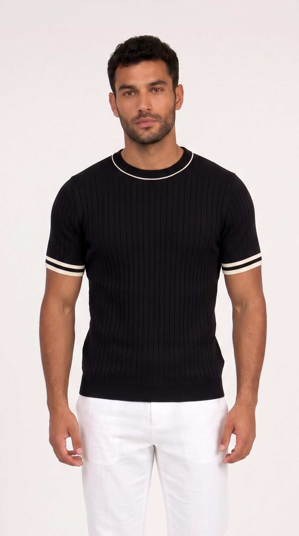A man wearing a black ribbed short-sleeve crewneck sweater with white contrast trim at the collar and sleeve cuffs, paired with white pants, against a plain light background, from Meleche Fashion USA or Meléche (short as (Mé))