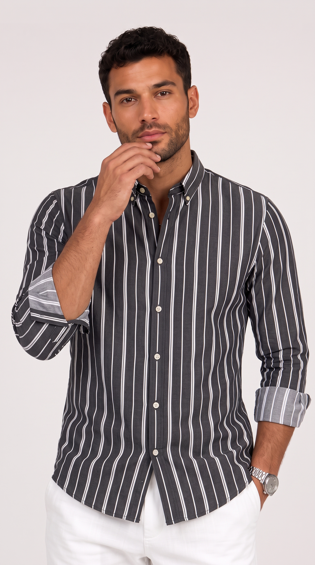 A man wearing a dark gray and white vertically striped button-down shirt with white pants, posing against a light gray studio background, from Meleche Fashion USA or Meléche (short as (Mé))