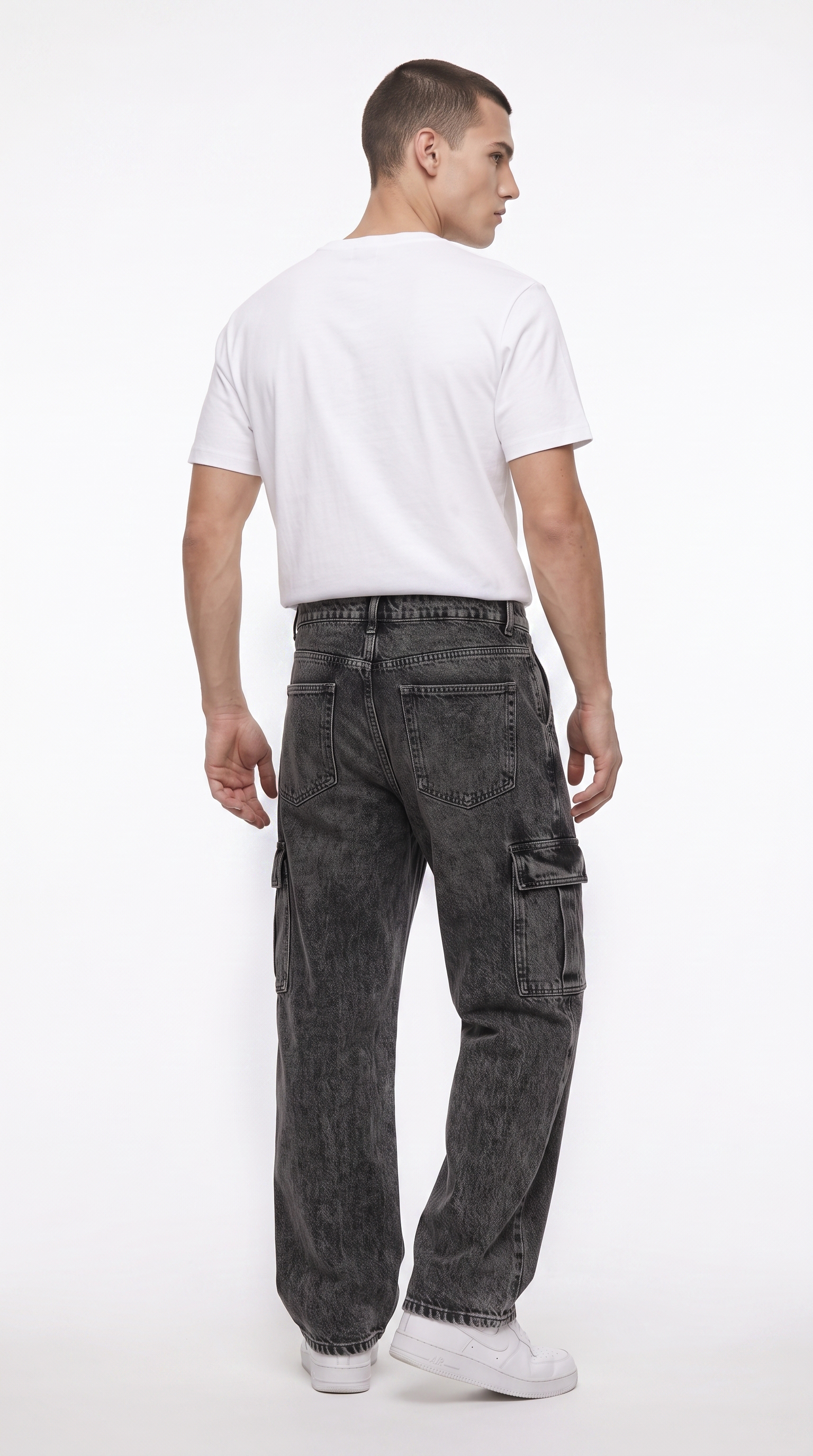 A man shown from the back wearing dark gray washed cargo jeans, a plain white t-shirt, and white sneakers against a white studio background, from Meleche Fashion USA or Meléche (short as (Mé))