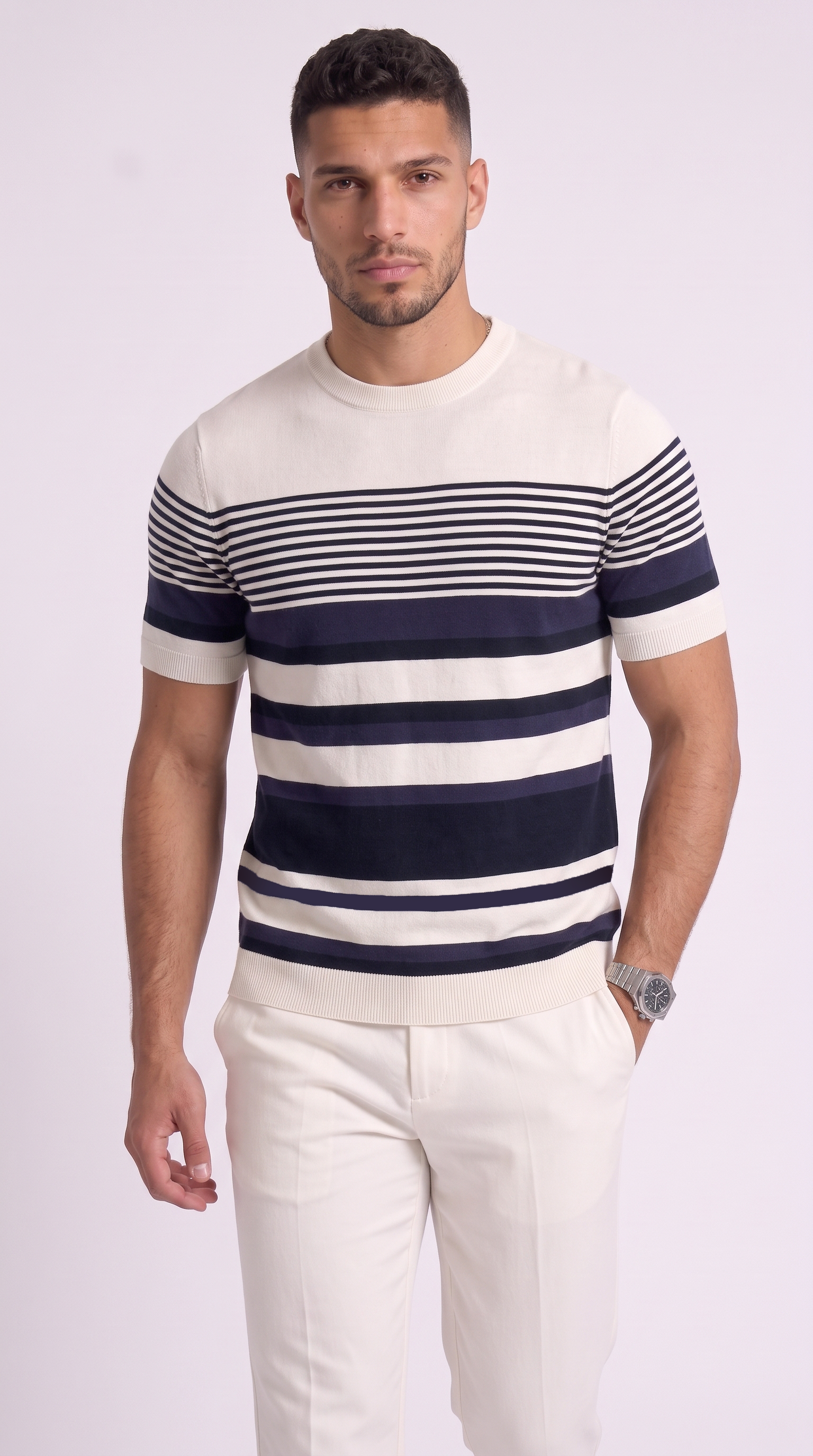 A man wearing a short-sleeve crewneck knit sweater with horizontal navy and off-white stripes, paired with off-white trousers, against a light studio background, from Meleche Fashion USA or Meléche (short as (Mé))