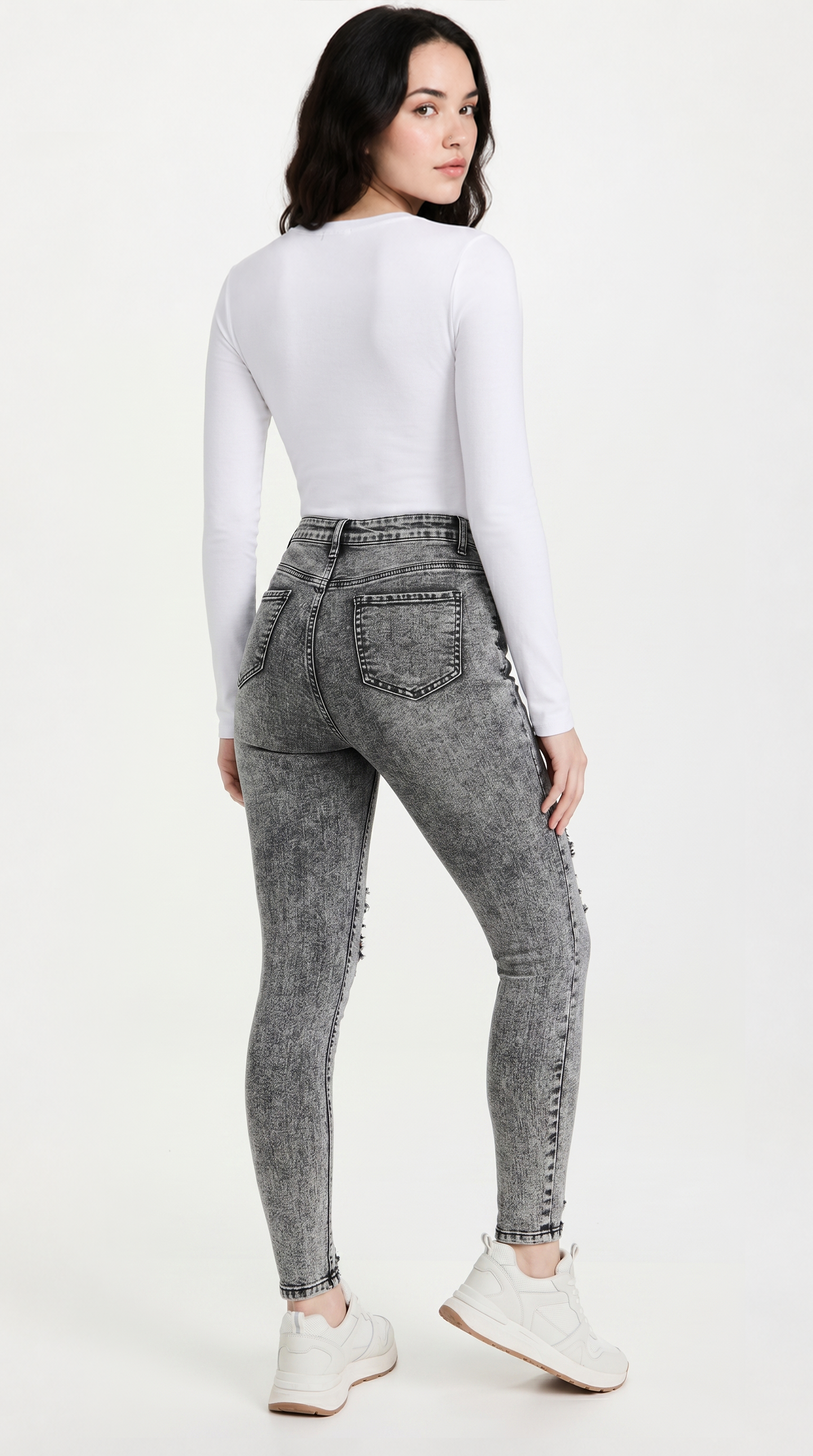 Person wearing gray acid-wash jeans and a white top on a white background, slim fit Skinny jeans from Meleche Fashion USA or Meléche (short as (Mé))