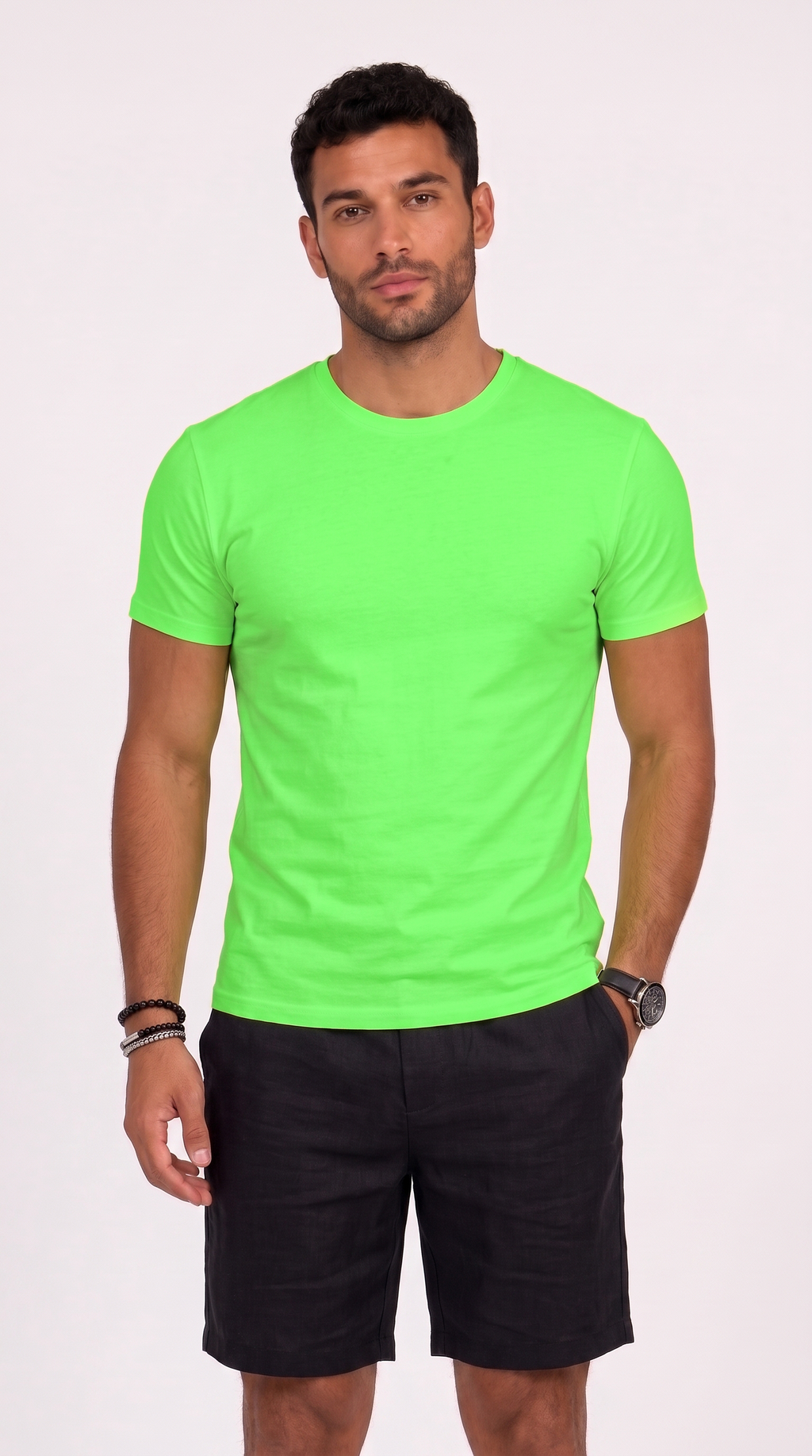 A man wearing a bright neon green short-sleeve crewneck t-shirt and black shorts, standing against a light off-white background, from Meleche Fashion USA or Meléche (short as (Mé))