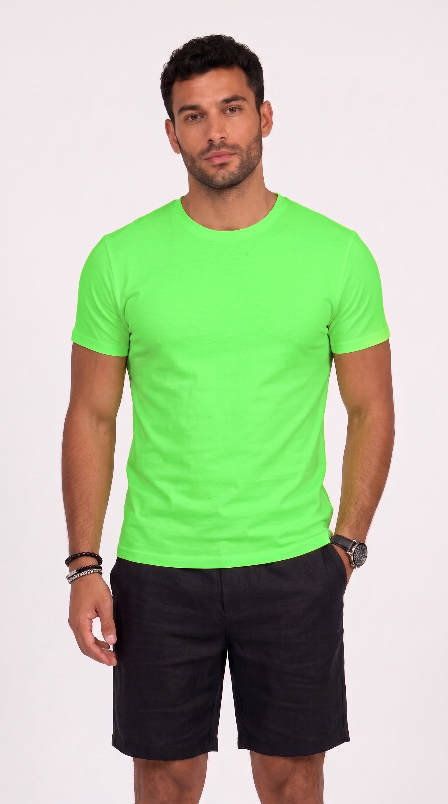 A man wearing a bright neon green short-sleeve crewneck t-shirt and black shorts, standing against a light off-white background, from Meleche Fashion USA or Meléche (short as (Mé))